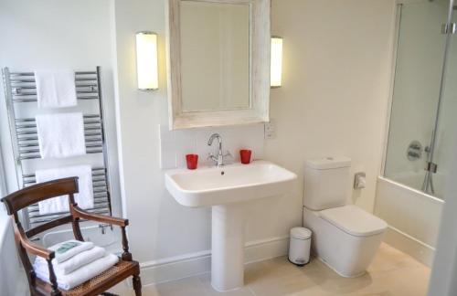 La salle de bains est pourvue d'un lavabo, de toilettes et d'un miroir. dans l'établissement Bang in Wells, à Wells-next-the-Sea