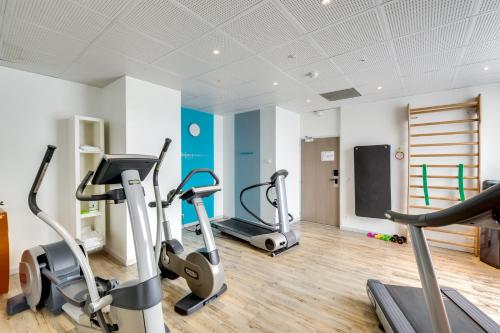 a gym with treadmills and ellipticals in a room at Novotel Suites Paris Montreuil Vincennes in Paris