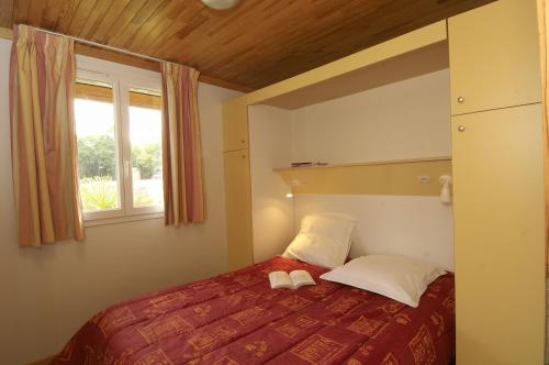a bedroom with a bed and a window at Domaine du Roi Kysmar in Villandraut