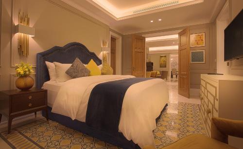 a bedroom with a large bed and a living room at Landmark Amman Hotel & Conference Center in Amman