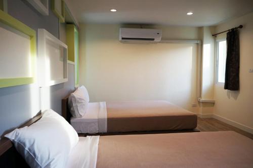 a hotel room with two beds and a window at Samsen Sam Place in Bangkok