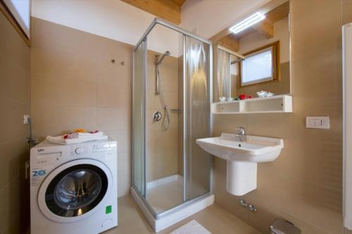 een badkamer met een wasmachine en een wastafel bij Paradiso del lago in Bellano