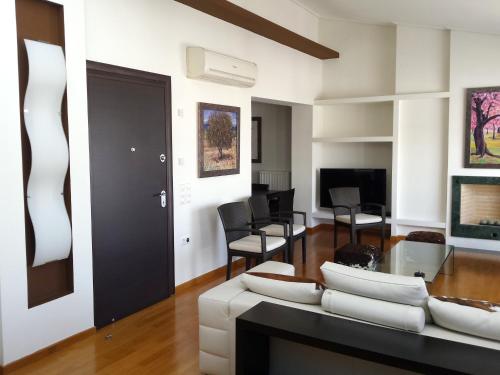 Elvita Athens Sea View Maisonette في أثينا: غرفة معيشة مع أريكة بيضاء وكراسي