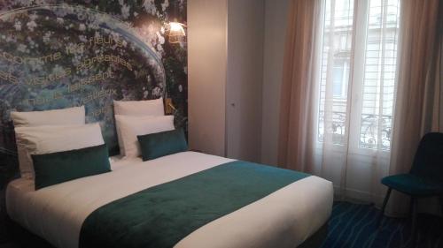 a bedroom with a large bed in front of a window at Hôtel Mercure Paris Suresnes Longchamp in Suresnes