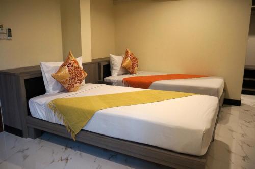 two beds in a hotel room with at Samsen Sam Place in Bangkok