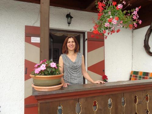 a woman standing behind a counter with a pot of flowers at Gästehaus Eschenhof in Reit im Winkl