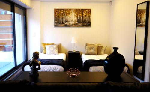 een woonkamer met 2 bedden en een tafel bij Home4you in Lissabon