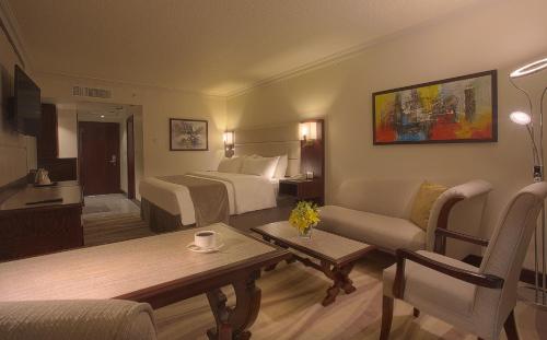 a hotel room with a bed and a living room at Landmark Amman Hotel & Conference Center in Amman