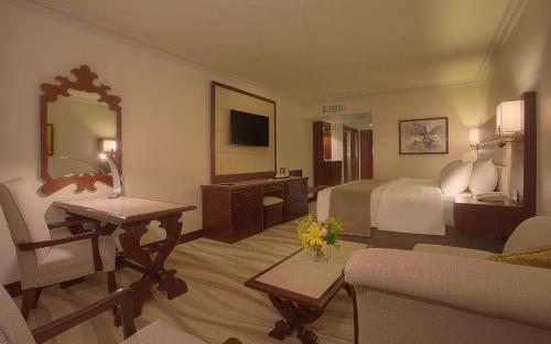 a hotel room with a bedroom with a bed and a desk at Landmark Amman Hotel & Conference Center in Amman