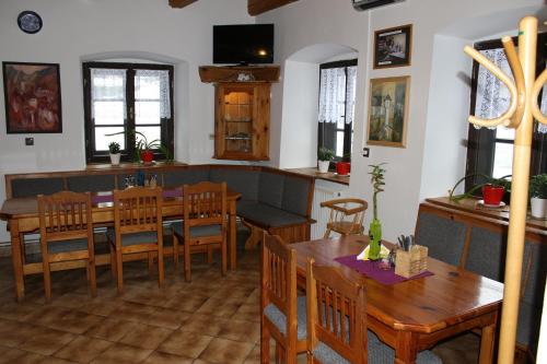 Un comedor con mesas y sillas de madera. en Penzion Klopacka, en Špania Dolina