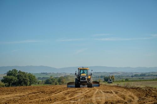 a tractor on a dirt road in a field at Agriturismo Podere La Rocca in Abbadia di Montepulciano