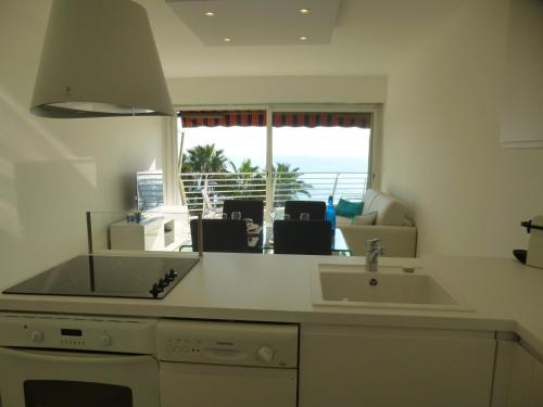 uma cozinha com um lavatório e vista para o oceano em Appartement Le Chantilly em Cagnes-sur-Mer