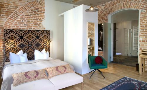 a bedroom with a bed and a brick wall at Emmerich Hotel Görlitz in Görlitz