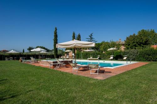 a swimming pool with chairs and umbrellas next to at Agriturismo Podere La Rocca in Abbadia di Montepulciano