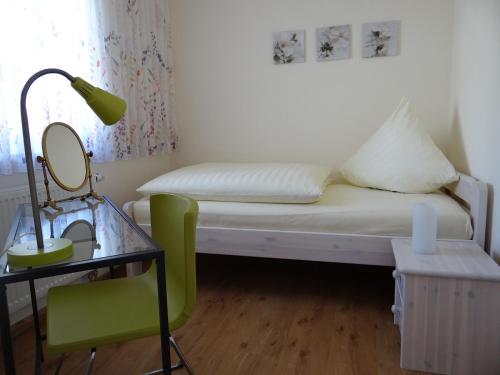 a small room with a bed with a mirror and a table at Villa Sonnenhof in Bad Steben