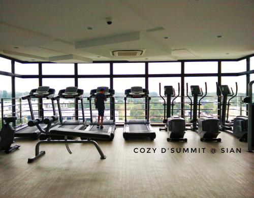 a person standing in a gym with cardio machines at COZY D'Summit 2 Bedrooms @ 100mbps HIGH SPEED WIFI in Skudai