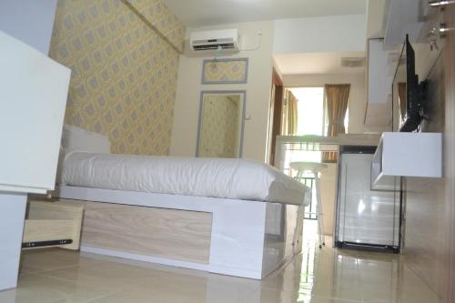 a bedroom with a white bed in a room at Green Lake View - Tower E 59 Acuan Laundry Time in Pondokcabe Hilir