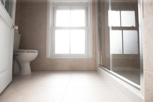 a bathroom with a toilet and a window at Bridge Hotel Brandon in Brandon