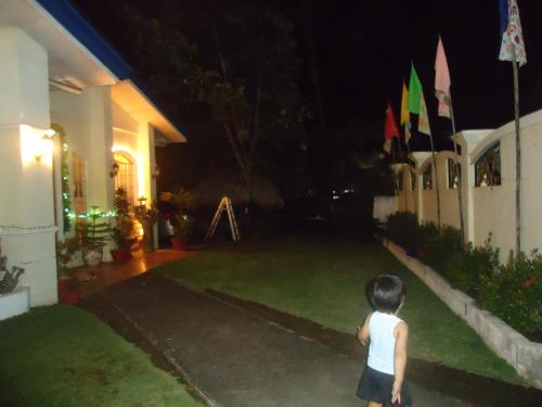 a young child standing in the yard of a house at night at Donsol Aguluz Homestay in Donsol