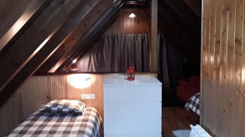 a room with a bed and a refrigerator in a attic at Hotelet de Betlan in Betlán