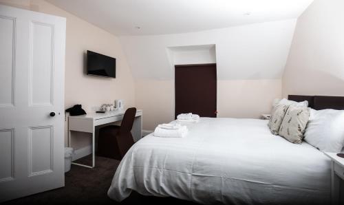 a bedroom with a bed and a desk with a computer at Bridge Hotel Brandon in Brandon