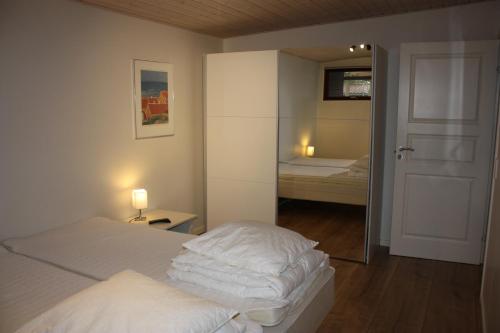 a bedroom with two beds and a mirror and a door at Skagen Ferie 1 in Skagen