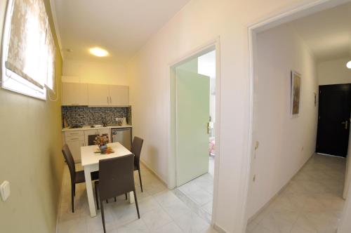 a kitchen and dining room with a table and chairs at Angels Pool Studios and Apartments in Paleokastritsa