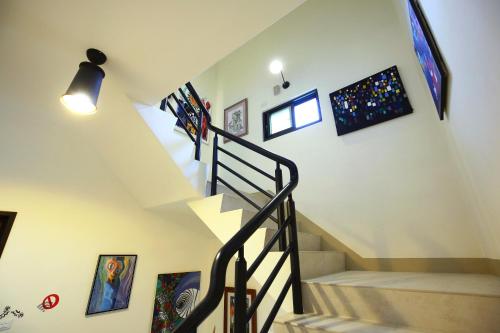 a spiral staircase in a home with art on the walls at 三匠獨棟庭園別墅 1歡唱烤肉打牌 -僅包棟 2聰明包棟-依人數提供床位及房間數 3寵物友善 4近夜市 in Jian
