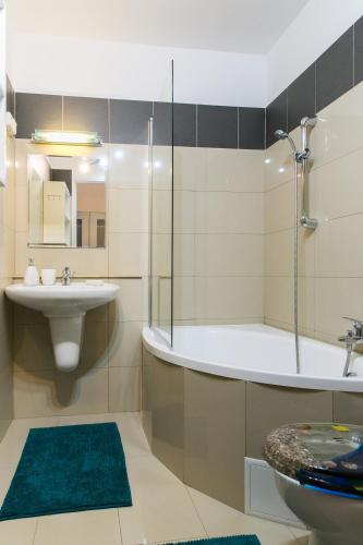 a bathroom with a sink and a tub and a toilet at Zielona Herbowa in Lublin