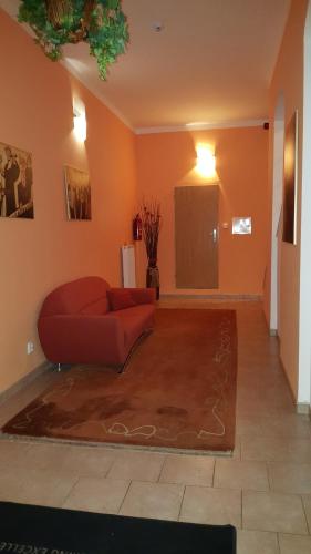 a living room with a red couch and a rug at Penzion PIANO & Apartment Sokolov in Sokolov