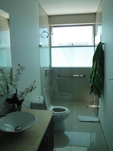 a bathroom with a sink and a toilet and a window at Apartamento Cartagena Alquiler - Edif Seaway 935 in Cartagena de Indias