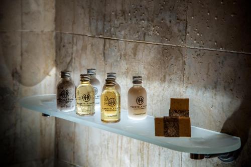 a shelf with four bottles of whiskey on it at Huentala Hotel in Mendoza