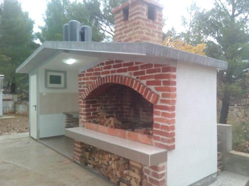 um forno de tijolo com uma chaminé no pátio em Apartments Begonia em Starigrad-Paklenica