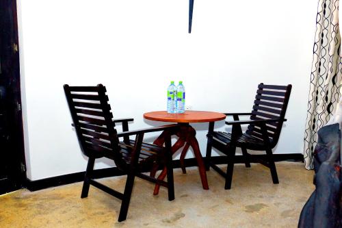 a table with two chairs and two water bottles on it at Turtle Watch Cabana in Tangalle
