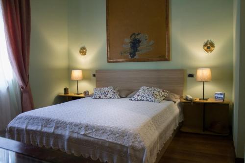 una camera con un letto con due lampade su due tavoli di Casa al borgo di Milazzo a Milazzo