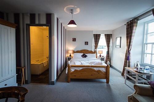 um quarto com uma cama e uma banheira. em The Dyvels Inn em Corbridge