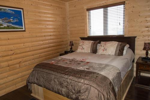 a bedroom with a bed in a log cabin at Burnt Cape Cabins in Raleigh