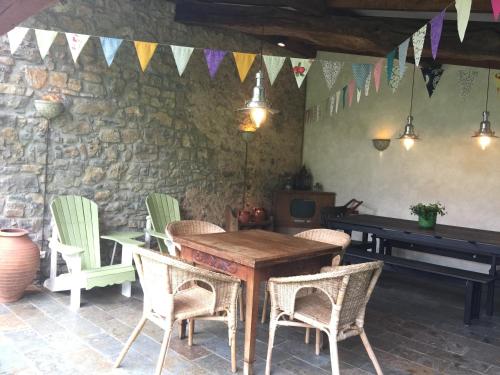 a table and chairs in a room with a piano at Casa De Vacaciones La Rivera in Villaviciosa