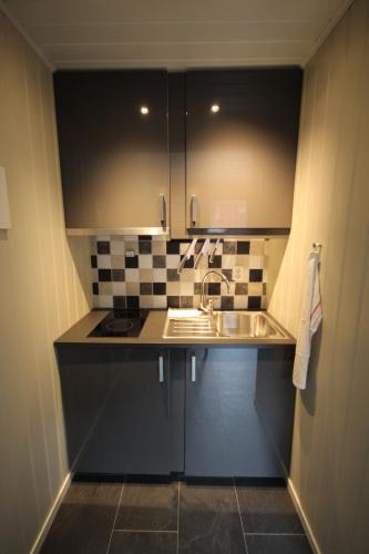 Una pequeña cocina con fregadero y encimera. en Bratland Camping, en Bergen