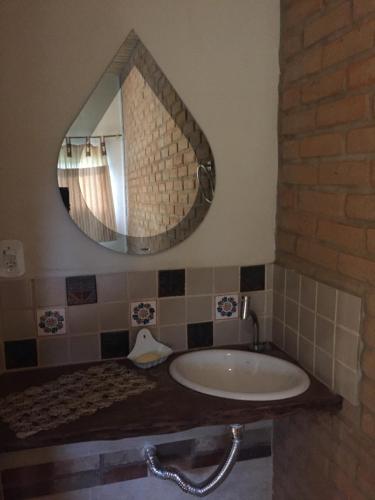 a bathroom with a sink and a mirror at Delirius Hospedagem in Itamonte