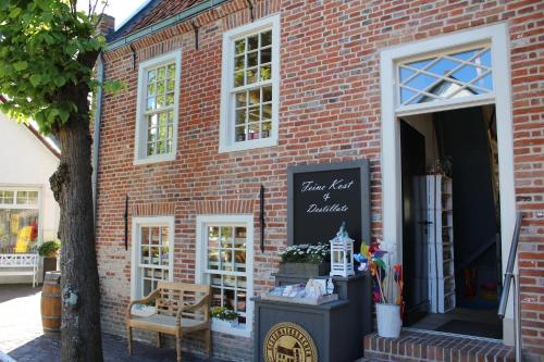 a store front of a brick building with a sign on it at Das GrachtenDOMiZiL Greetsiel in Greetsiel