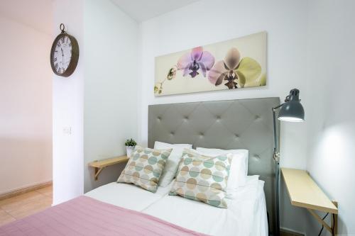 1 dormitorio con cama blanca y cabecero gris en Boutique Holiday Spot, en Adeje
