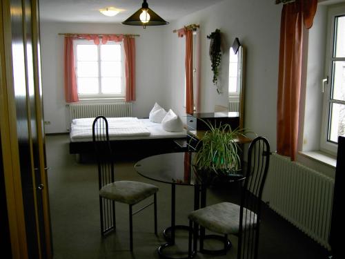 a room with a bed and a table and chairs at Landhotel am Fuchsbach in Berga