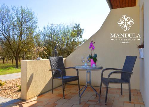 a table and chairs sitting on a patio at Mandula Apartman in Cegléd