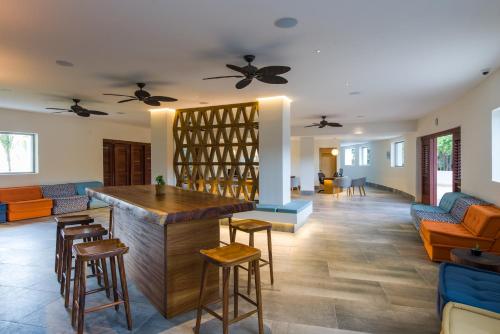 a living room with a bar and some chairs at Izla Beach Front Hotel in Isla Mujeres