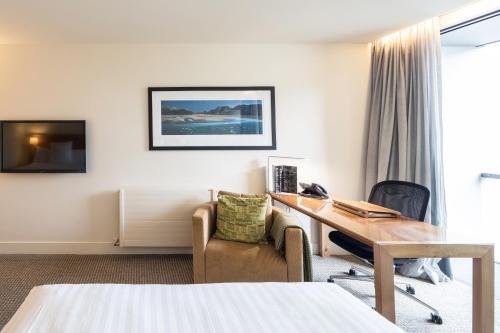 a hotel room with a desk and a chair at Commodore Airport Hotel Christchurch in Christchurch