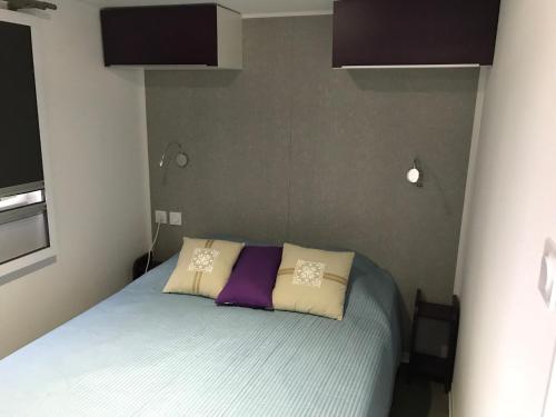 a bedroom with a bed with two pillows on it at CosyStudio Site du Futuroscope in Chasseneuil-du-Poitou