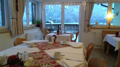 a dining room with two tables with white tablecloths at Haus Hepi in Obertraun