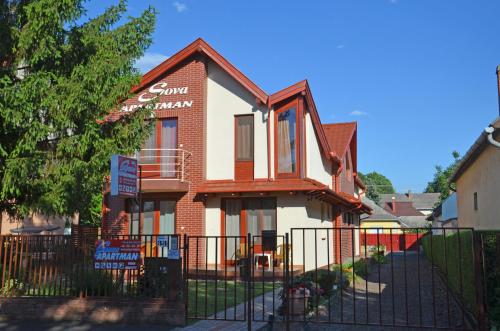 a building with a fence in front of it at SovaApartman in Hajdúszoboszló