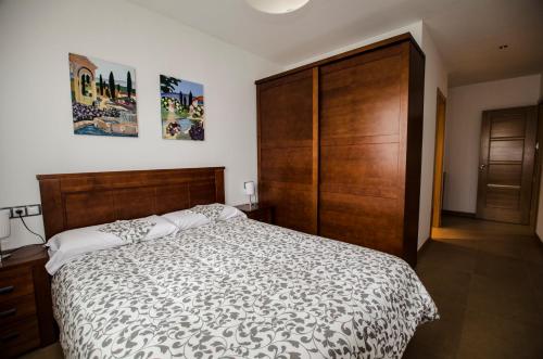 una camera con un grande letto e un grande armadio in legno di Casa Rural La Guea de Teruel a Teruel